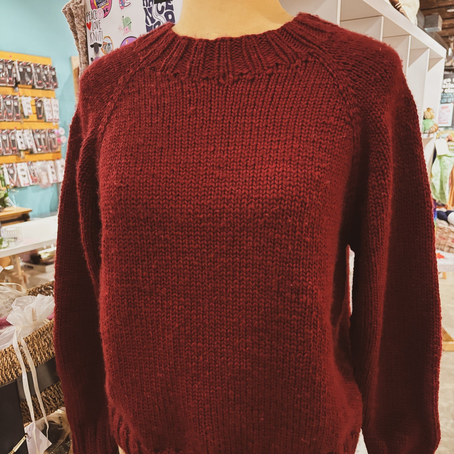 Red sweater on a mannequin in a store setting