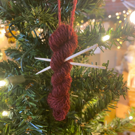 Red mini yarn skein and knitting needles ornament on a Christmas tree
