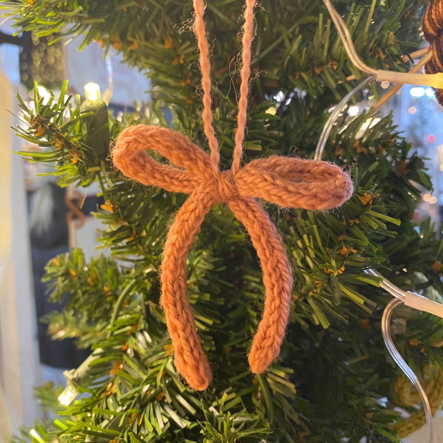 Pink knitted bow ornament on a Christmas tree