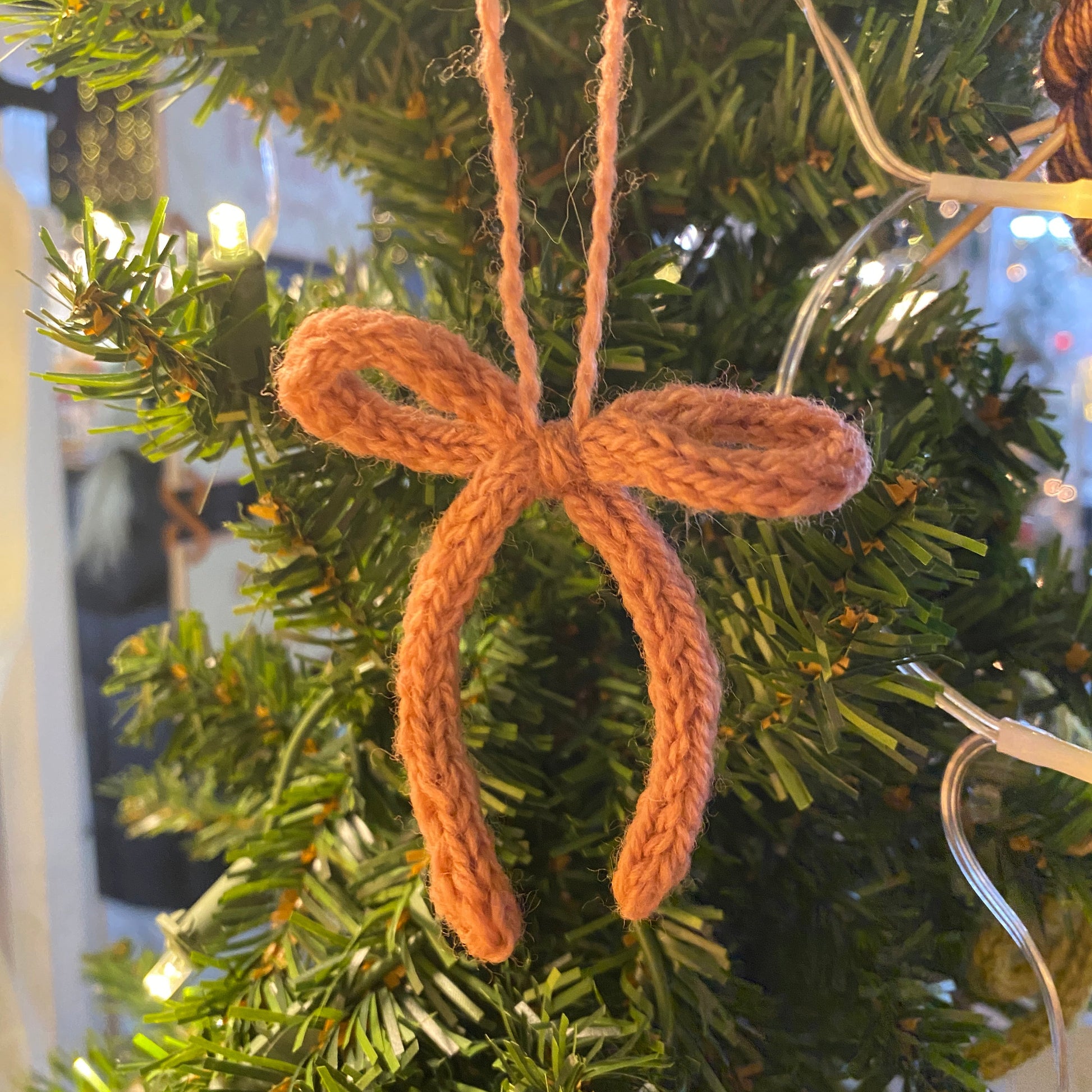 Pink knitted bow ornament on a Christmas tree