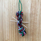 mini yarn skein ornament with toothpick knitting needles in red, green, black, and white