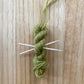 mini yarn skein ornament with toothpick knitting needles in lime green