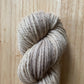 skein of beige yarn on a wooden surface