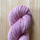Pink skein of yarn on a wooden surface