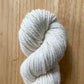 White skein of yarn on a wooden surface