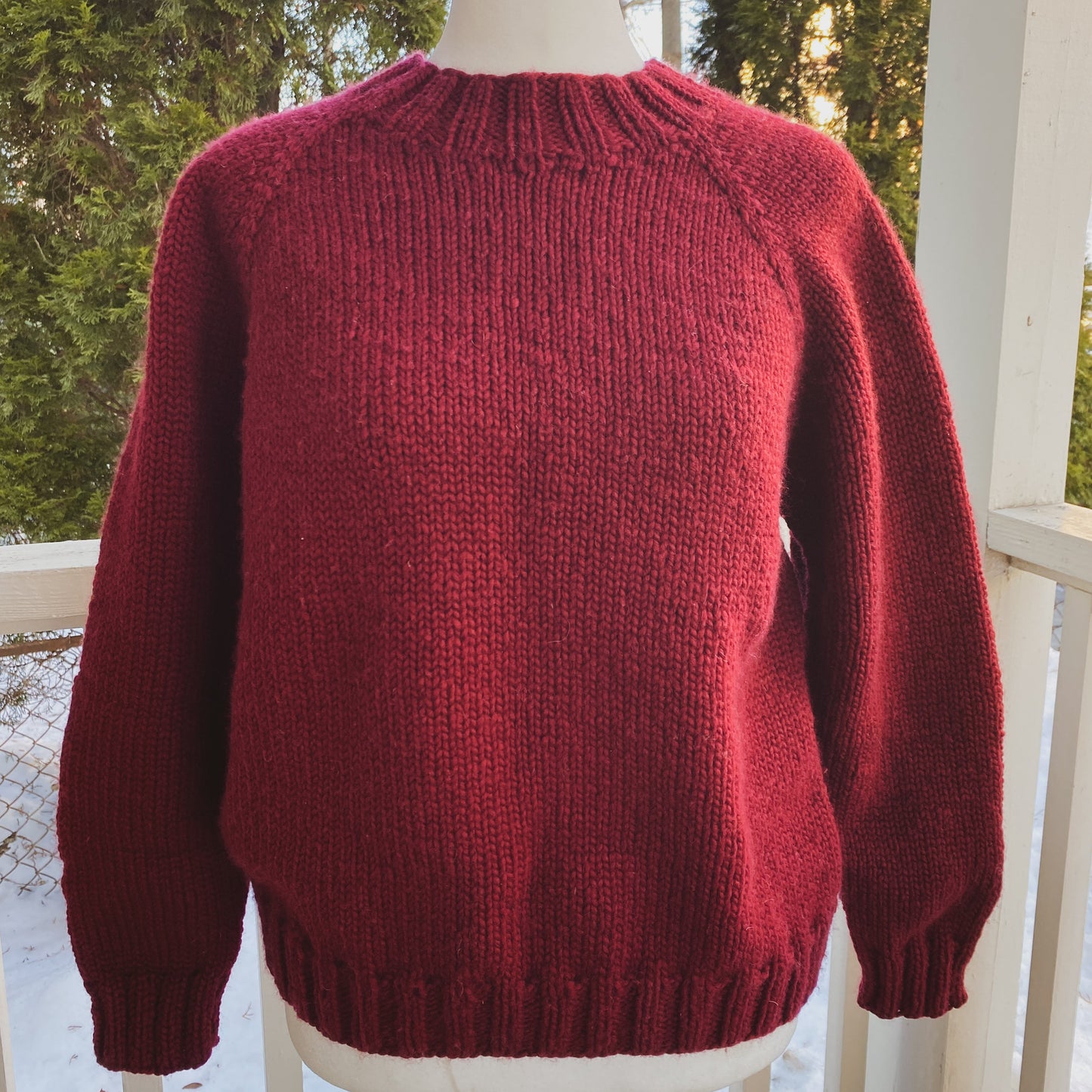Red sweater on a mannequin against a snowy outdoor background
