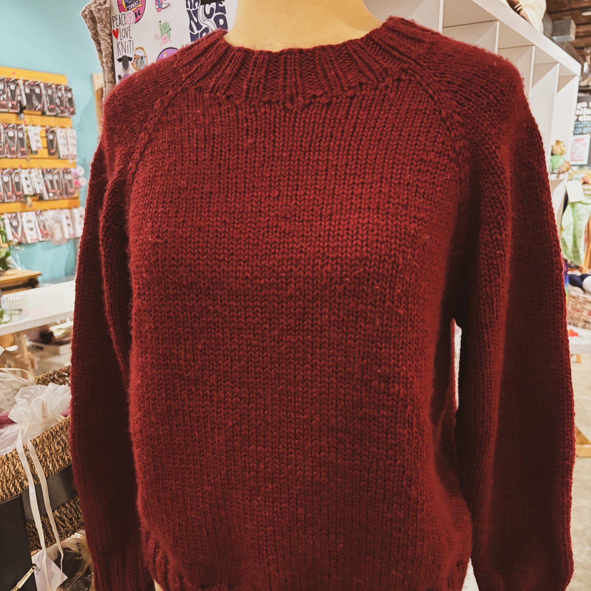 Red sweater on a mannequin in a store setting