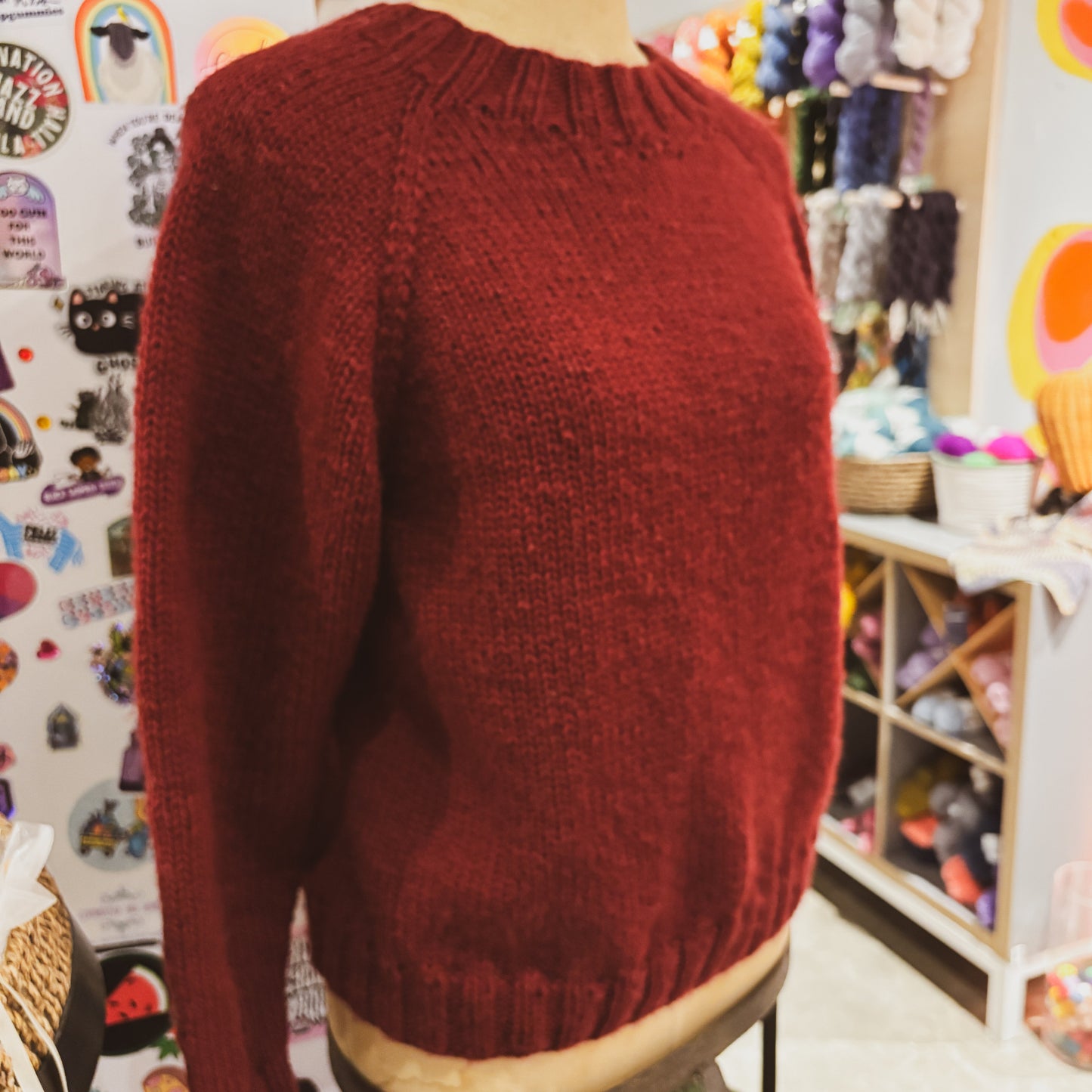 Red sweater on a mannequin in a craft store setting