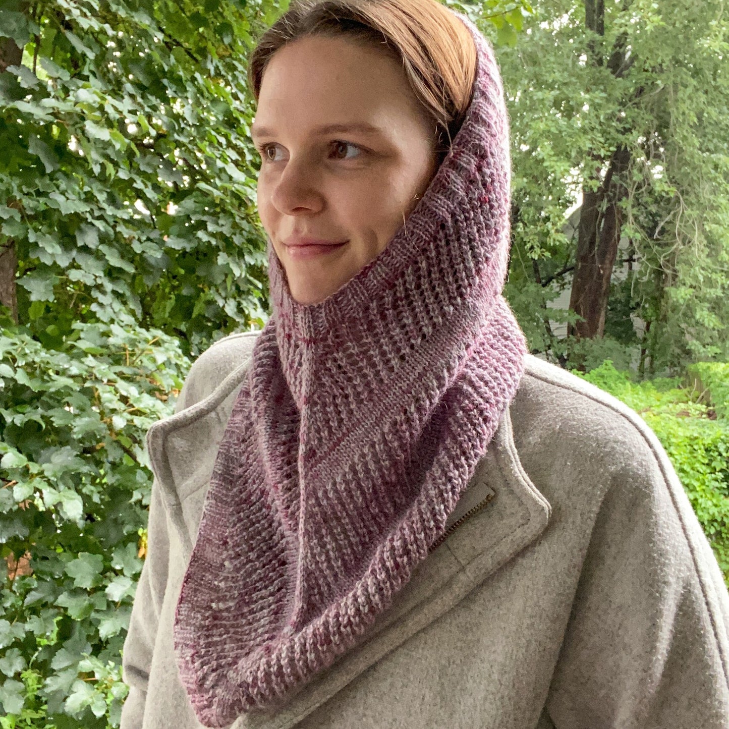 jules, the designer, wearing a lace striped cowl with ribbing in a purple/pink yarn