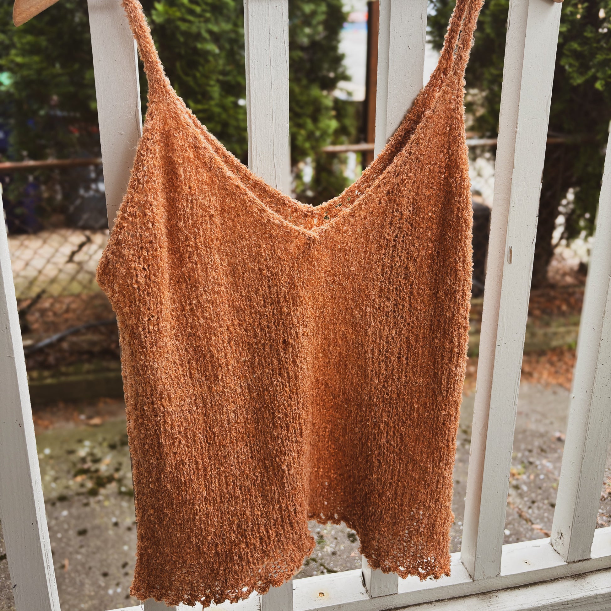 knitted tank top in orange/brown boucle yarn with a picot hem.